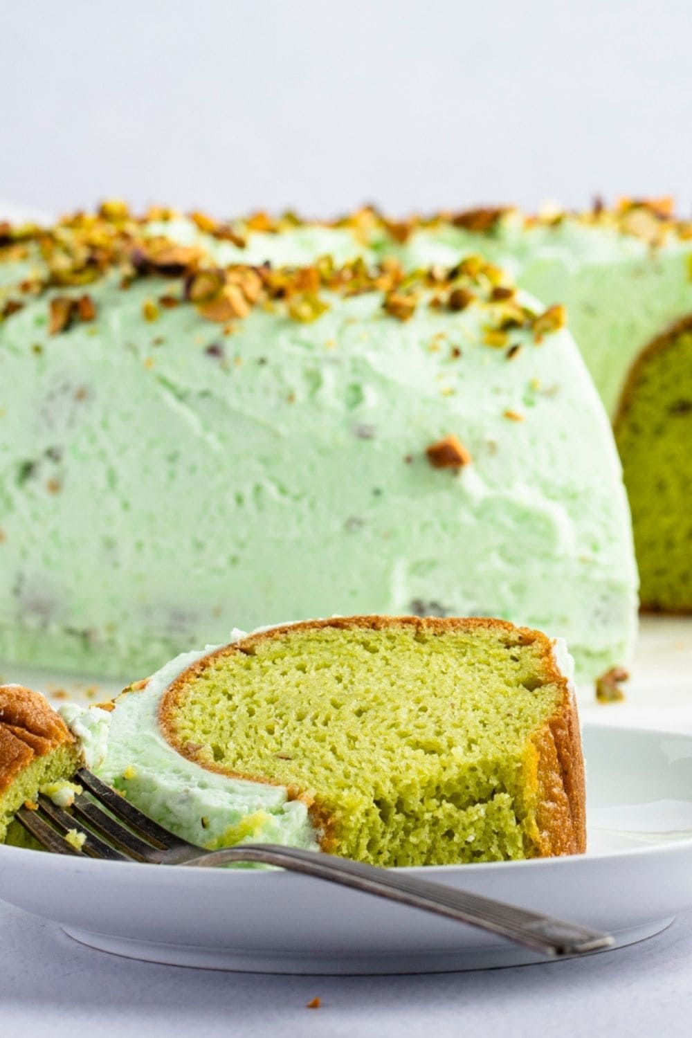 A Slice of Pistachio Cake Served on a Plate With Fork