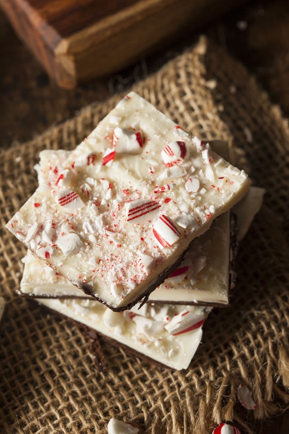Chocolate peppermint barks layered on each other on top of a brown cloth.