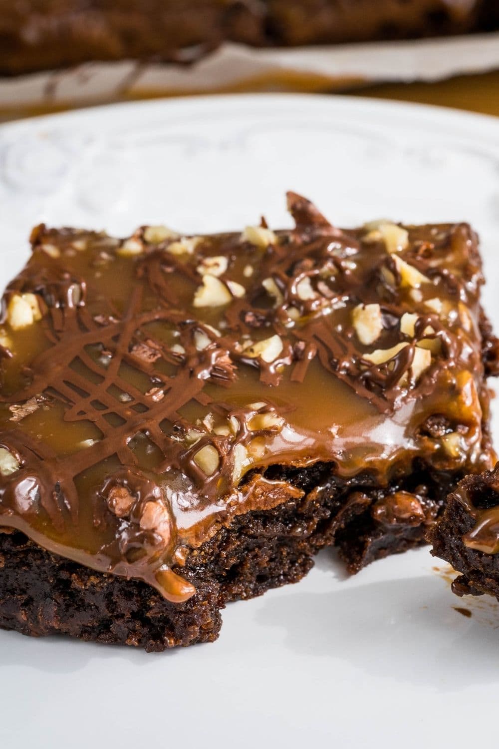 Fudgy and moist slice of brownie topped with caramel sauce and chopped nuts.