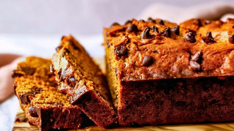 Side View of Pumpkin Chocolate Chip Bread Loaf with Slices Cut on a Wooden Cutting Board