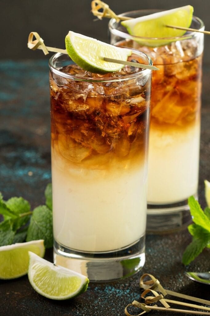 Dark and Stormy Cocktail with Ginger Ale and Rum, garnished with a Lime Wedge