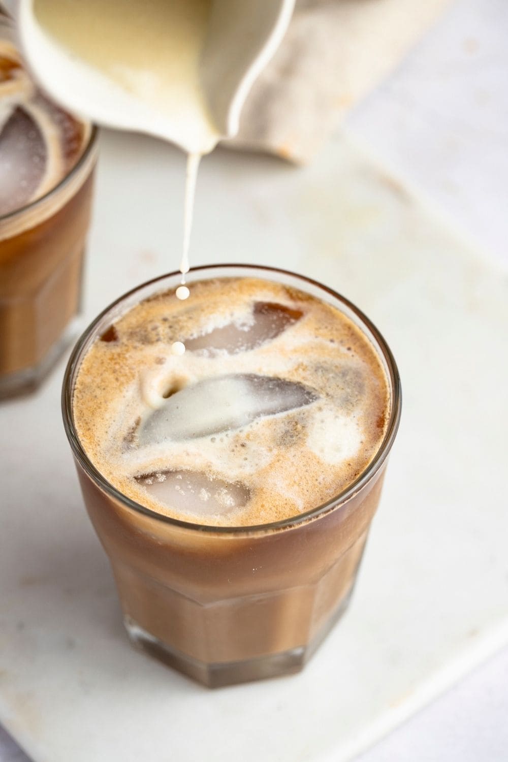 Pouring Milk in a Glass of Banana Milk Coffee