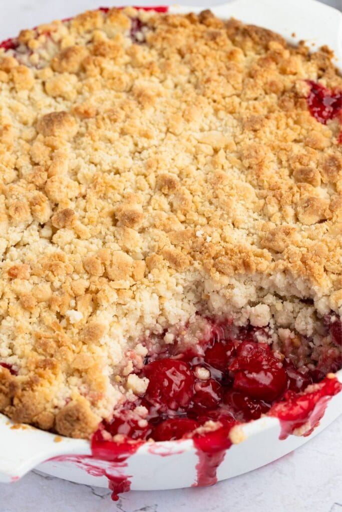 Cherry cobbler with cake mix. Photo shows Sweet and Crumbly Cherry Cobbler in a white baking dish
