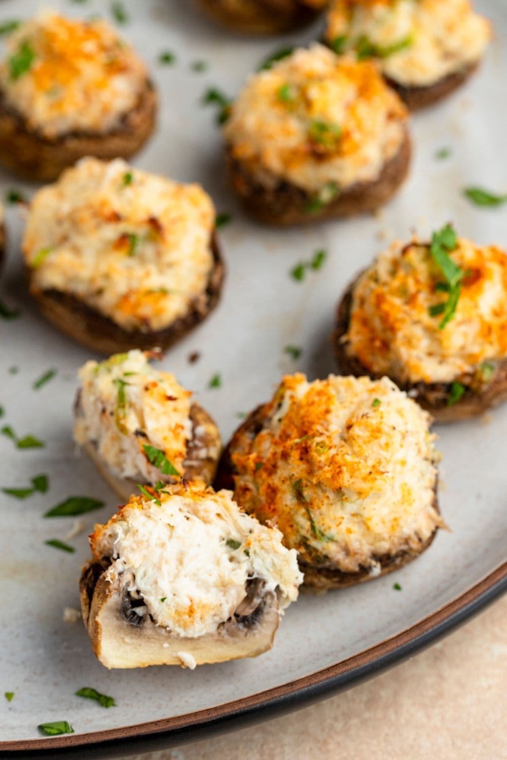 Pieces of crab stuffed mushroom served on a plate. 