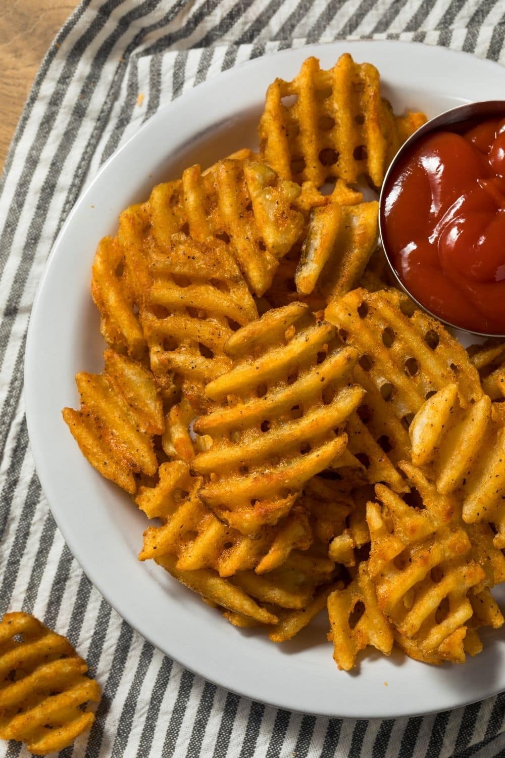 Waffle fries on a plate with ketchup