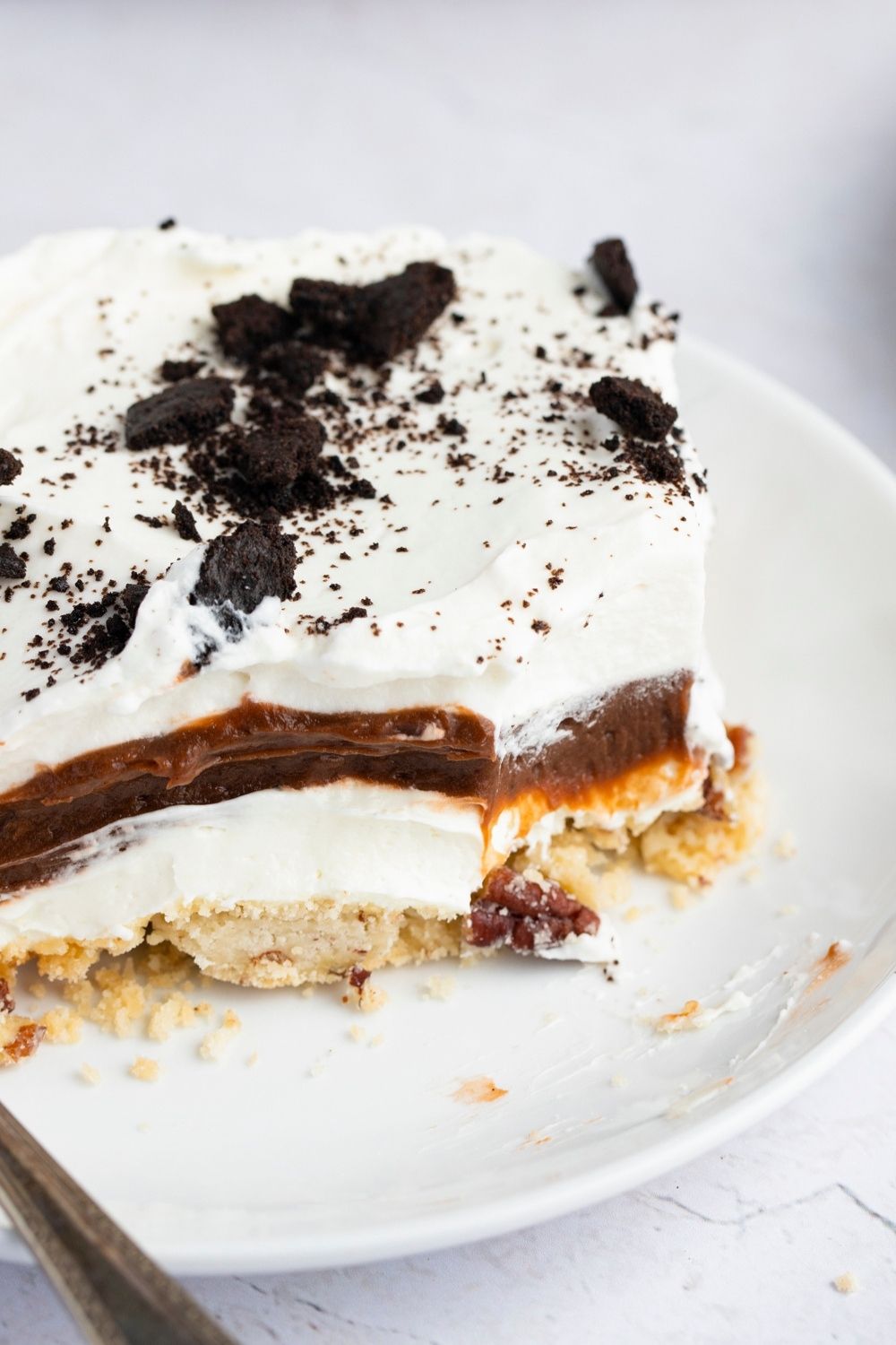 A Slice of Sex in a Pan Composed of Crust, Mousse, and Cheesecake Layers with Oreo Crumble on Top
