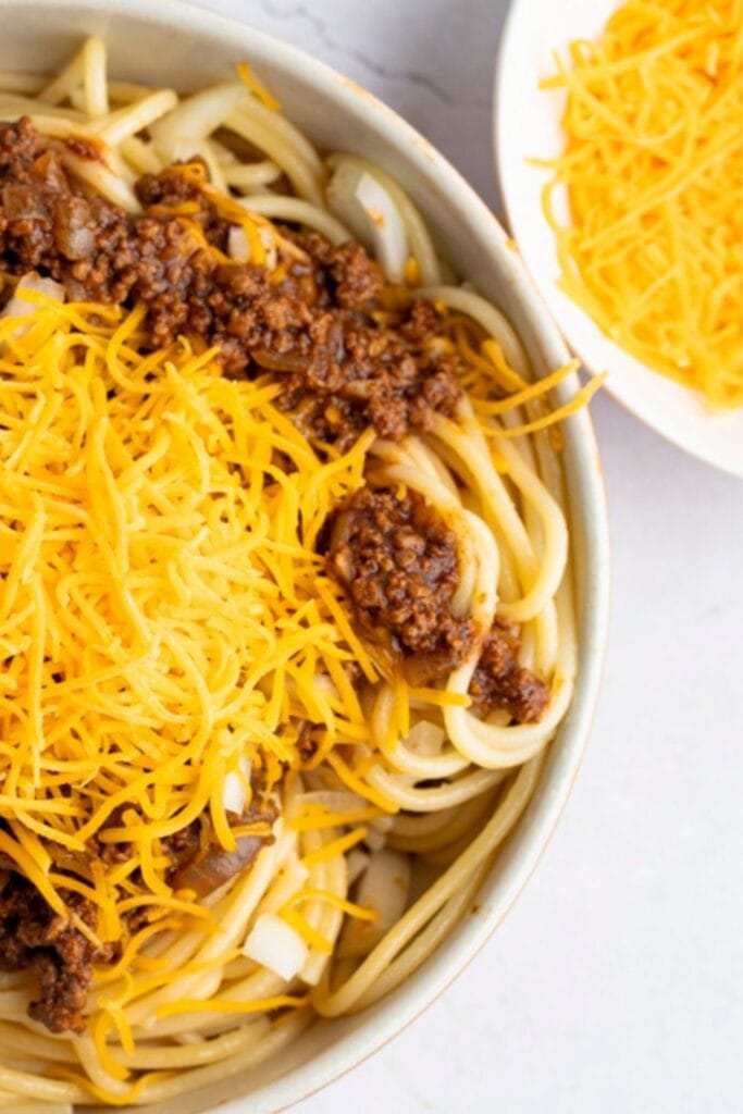 Copycat Skyline Cincinnati Chili with Shredded Cheese and Spaghetti noodles.