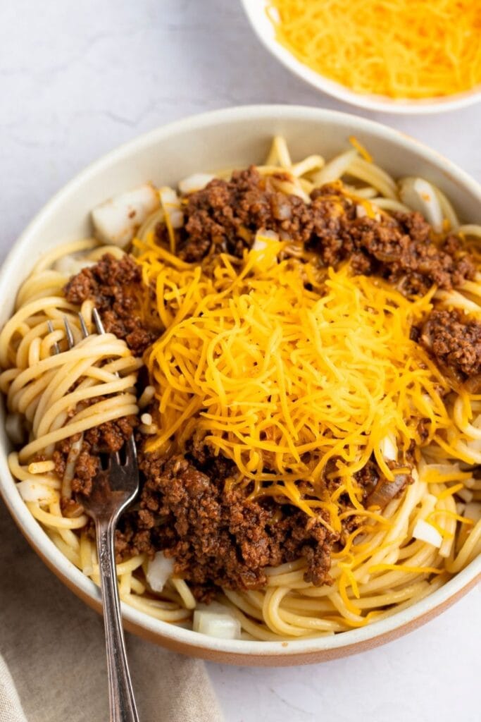 Copycat Skyline Cincinnati Chili topped with ground beef and cheddar cheese. Midwestern favorite!