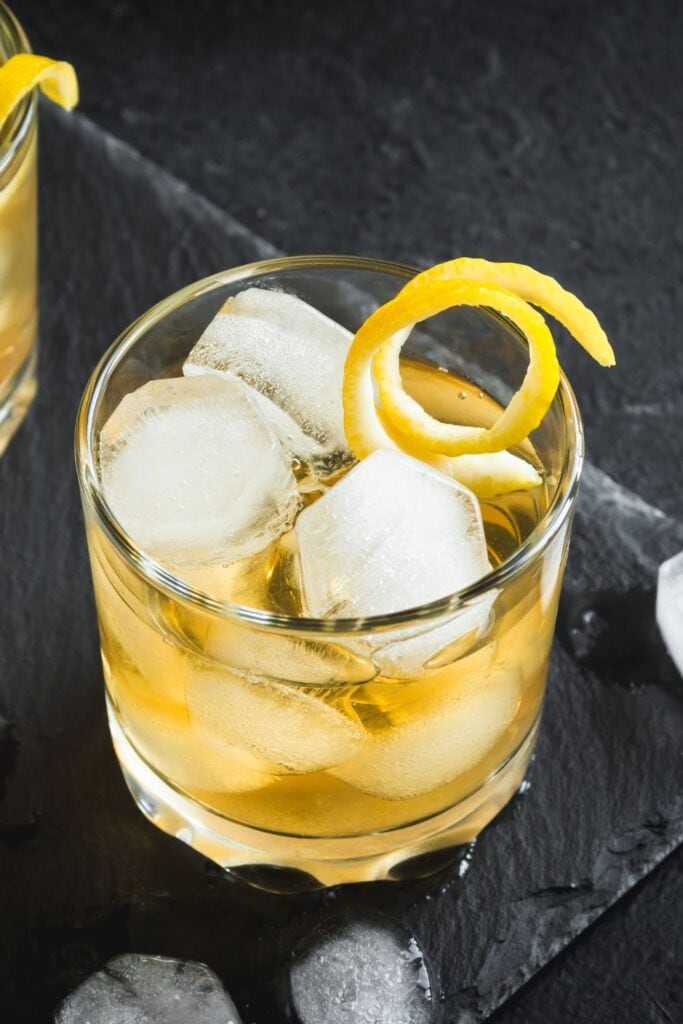 Refreshing Whiskey Cocktail with Ice Cubes and Garnished with a Lemon Twist