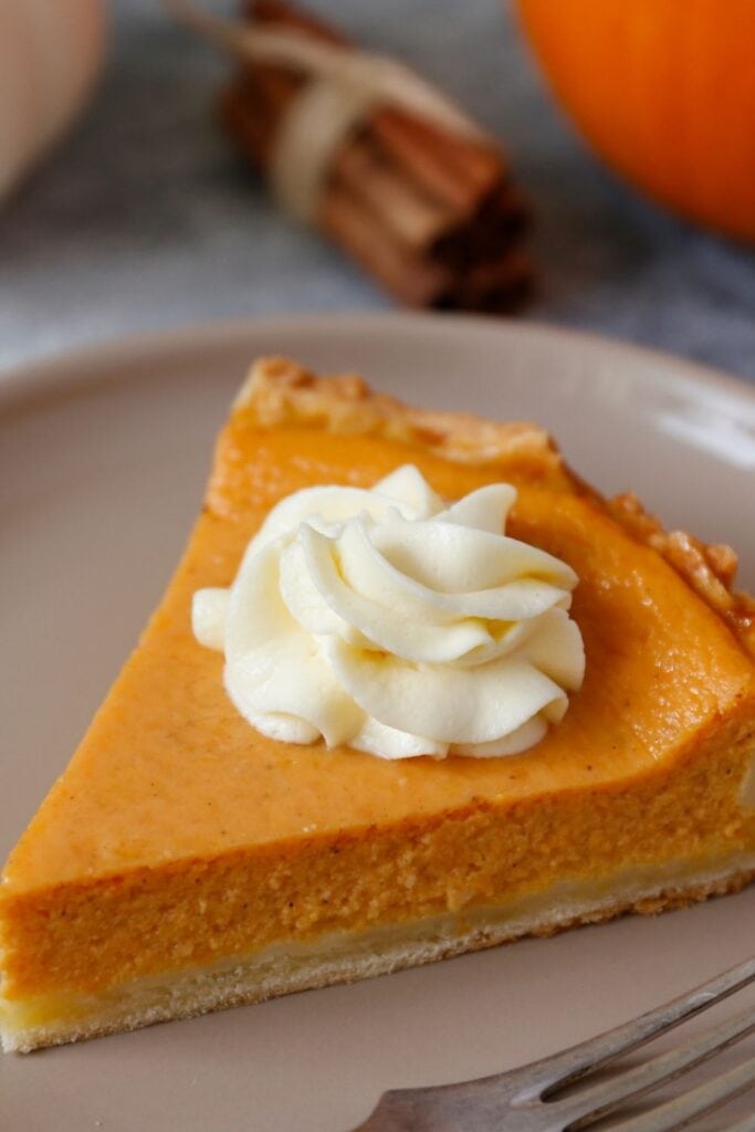 Slice of Pumpkin Pie with Whipped Cream in a Plate