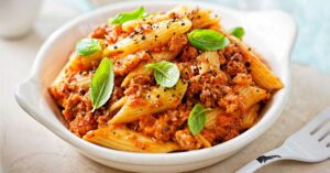 Homemade Penne Pasta with Tomato Sauce, Minced Sausage and Basil