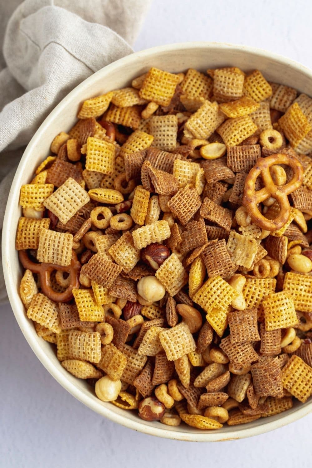 Combination of Chex cereals, pretzels, and nuts in a bowl.