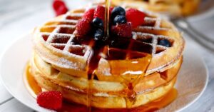 A Stack of Waffles with Maple Syrup and Berries
