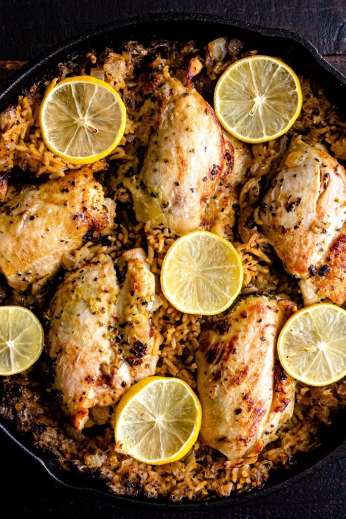 Baked Chicken Thighs with Lemons and Rice in a Skillet