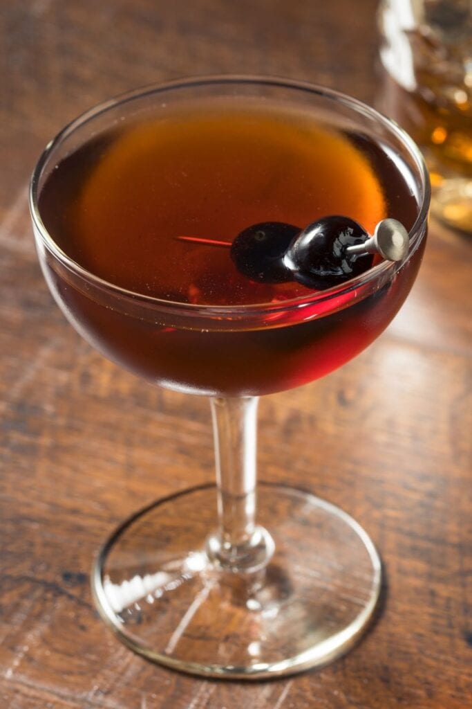 Рецепты классических коктейлей с вермутом. На фото коктейль Boozy Manhattan с вермутом и вишневым гарниром.