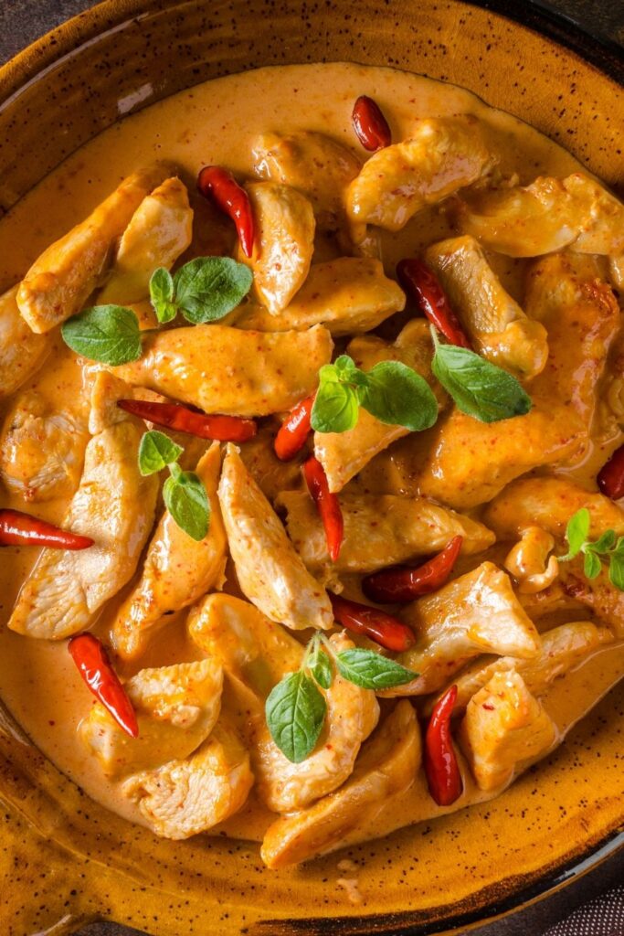 20 Authentic Thai Curry Recipes. Photo shows red pork belly curry with spices in a bowl