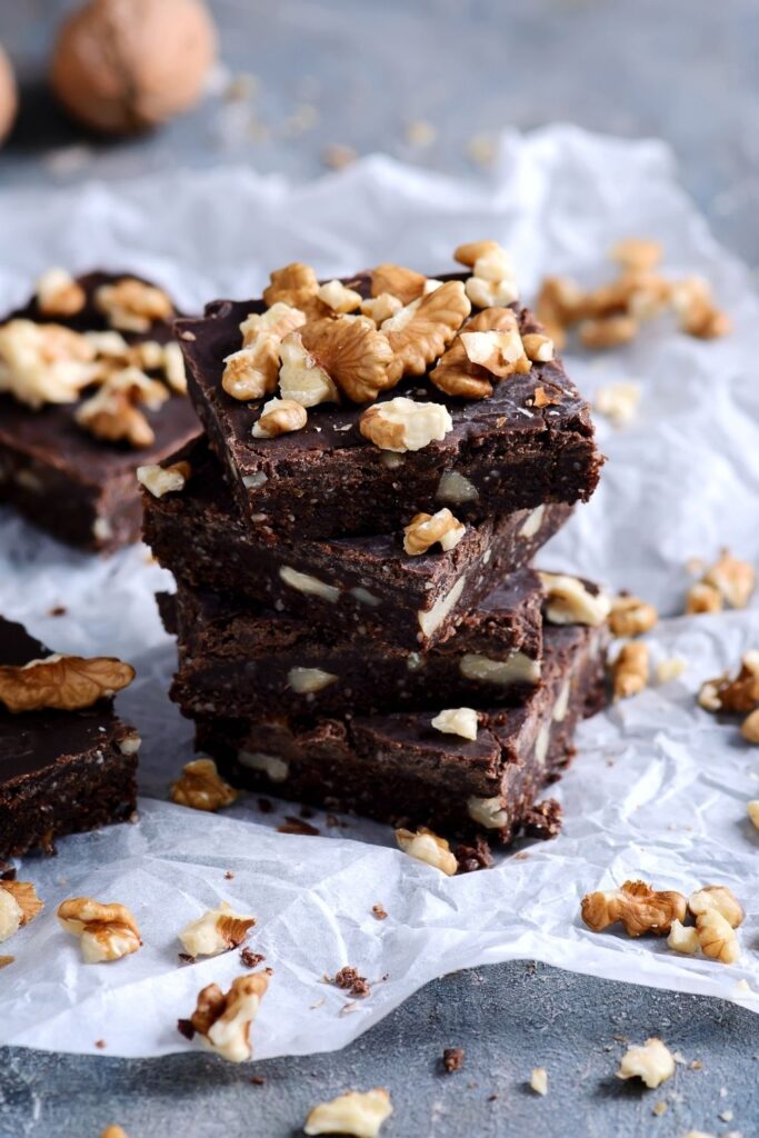 Whole30 desserts that will satisfy your cravings but still keep your diet on track. Enjoy a sweet treat with these Whole30 recipes! Vegan brownie shown in photo with nuts on top. 