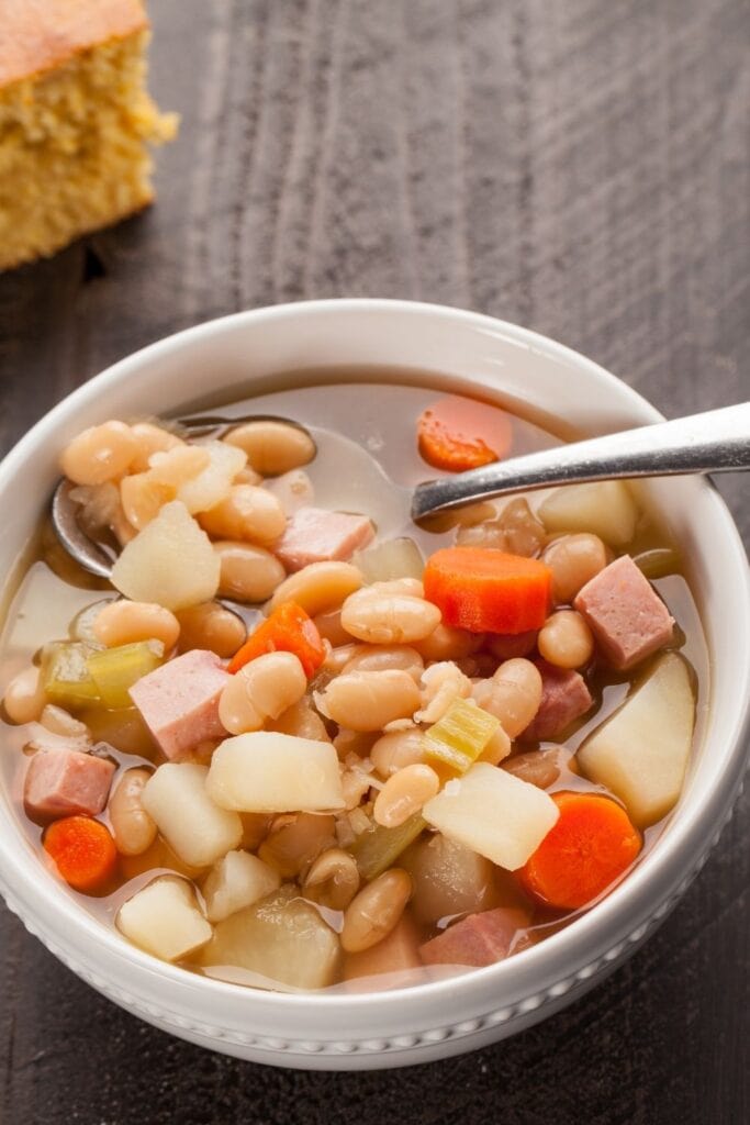 Old-Fashioned Ham and Bean Soup recipe. Photo shows a bowl of Warm Ham and Bean Soup with Carrots and Northern Beans