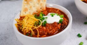 Bowl of Homemade Ground Turkey Chili with Cheese and Crackers