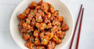 Chili Chicken with Sesame Seeds and Green Onions in a Bowl