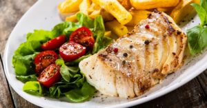 Grilled Cod Loin with French Fries and Vegetables and Tomatoes