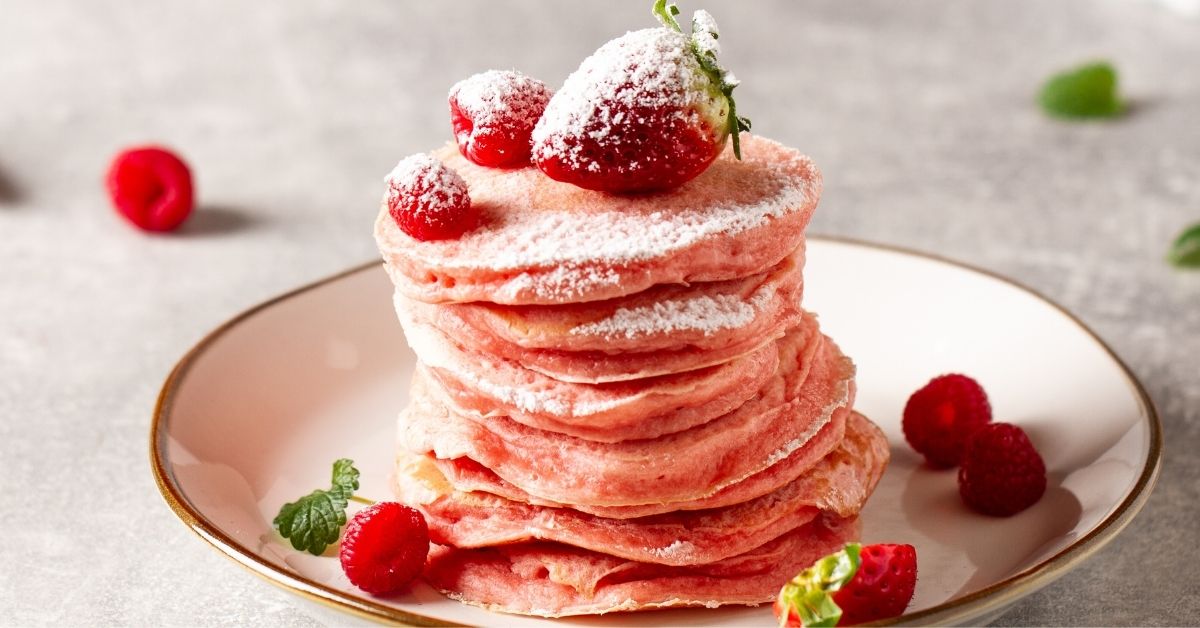Homemade Pink Pancakes with Powdered Sugar and Strawberries