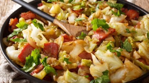 Homemade Stir-Fry Cabbage with Bacon in a Black Plate