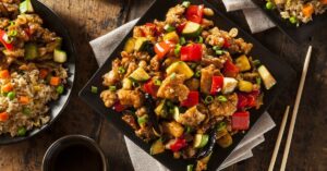 Kung Pao Chicken with Peppers and Veggies in a Black Plate