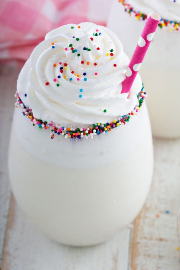 Easy Milkshake Recipes To Make At Home. Photo shows Refreshing Vanilla Funfetti Milkshake with sprinkles and a pink polka dot straw