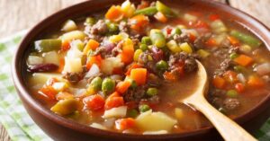 Warm Homemade Beef and Vegetable Soup with Carrots, Peas, Corn and Beans