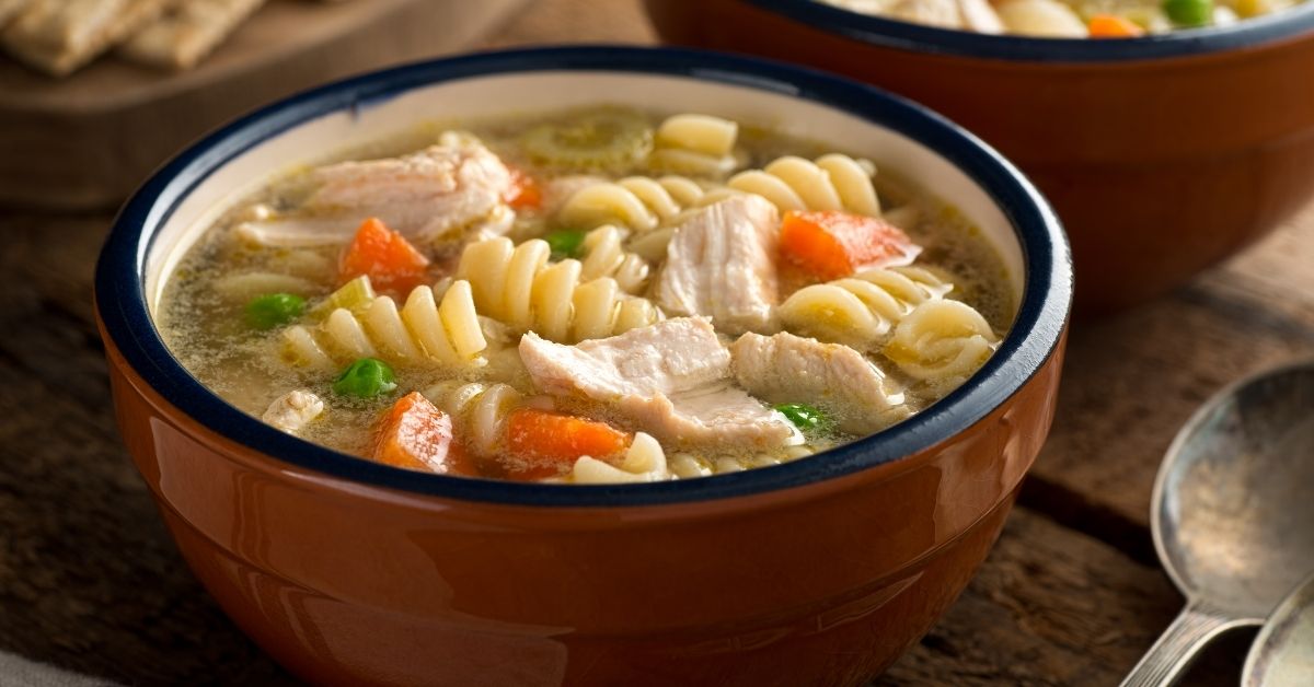Warm Homemade Chicken Noodle Pasta Soup with Carrots and Peas
