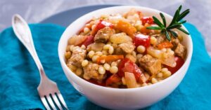 A Bowl of Fregola Pasta with Vegetables and Meat