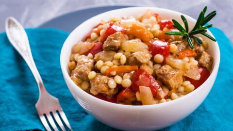 A Bowl of Fregola Pasta with Vegetables and Meat