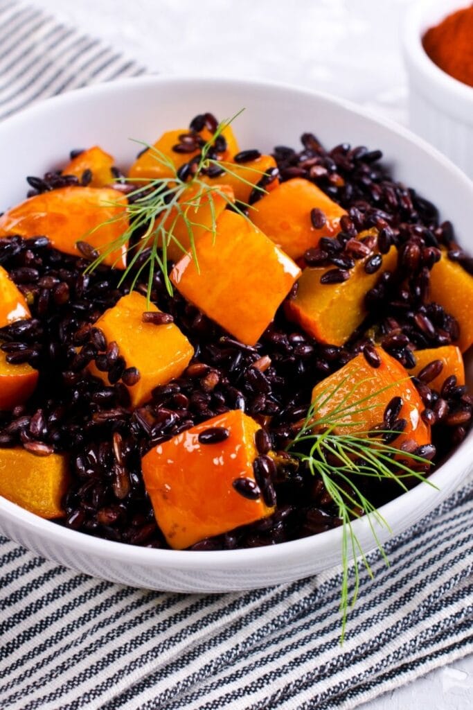 20 Easy Black Rice Recipes Fit for a King featuring Black Rice with Pumpkin in a White Bowl