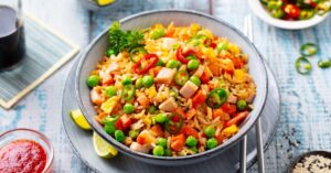 Homemade Fried Rice with Spam, Carrots and Green Peas in a Bowl