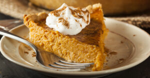 Homemade McCormick Pumpkin Pie with Whipped Cream and Pumpkin Pie Spice in a White Plate