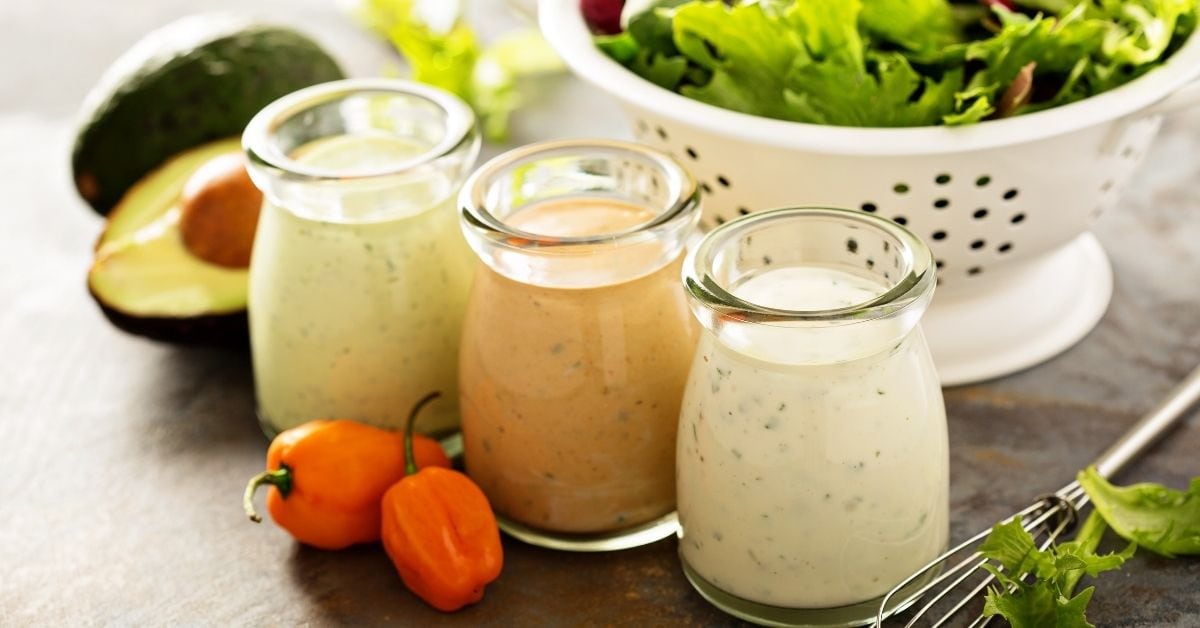 Salad Dressings in Glass Jars with Herbs, Avocado and Peppers