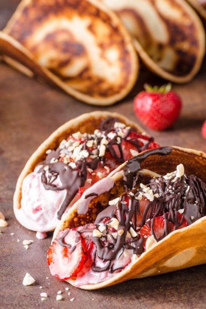 25 Easy Dessert Tacos You Don’t Want To Miss featuring Sweet Taco Dessert with Strawberries and Chocolate Syrup