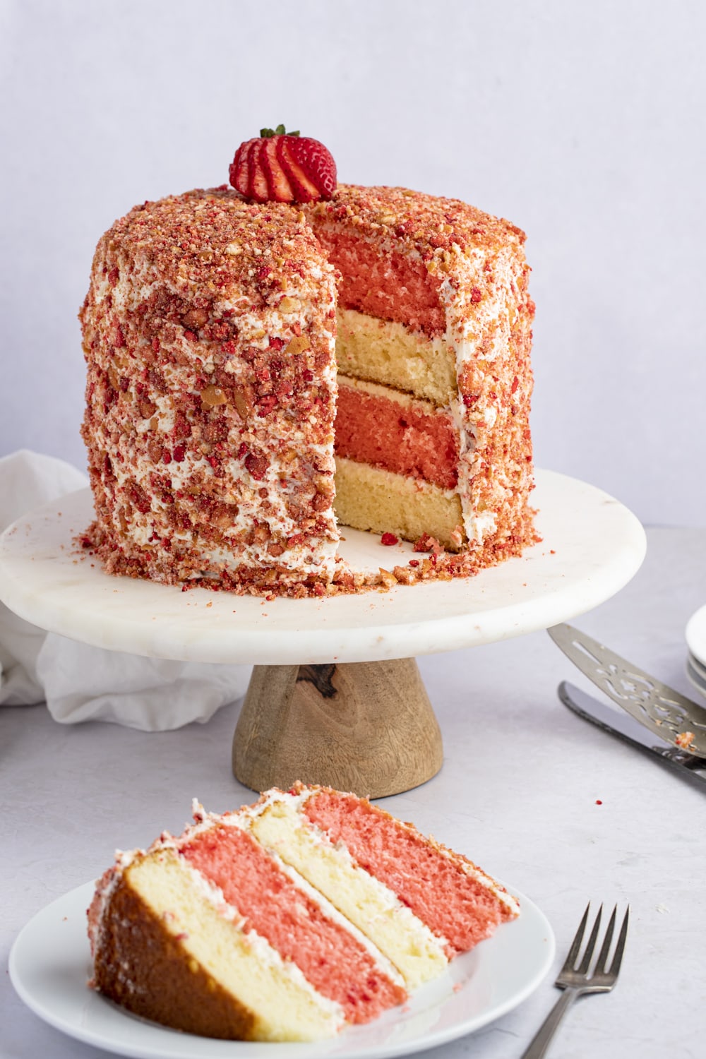 Sweet Strawberry Crunch Cake on a Stand with One Slice Removed