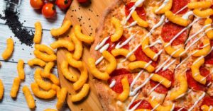 Tasty Salami Pizza with Cheetos on a Wooden Board