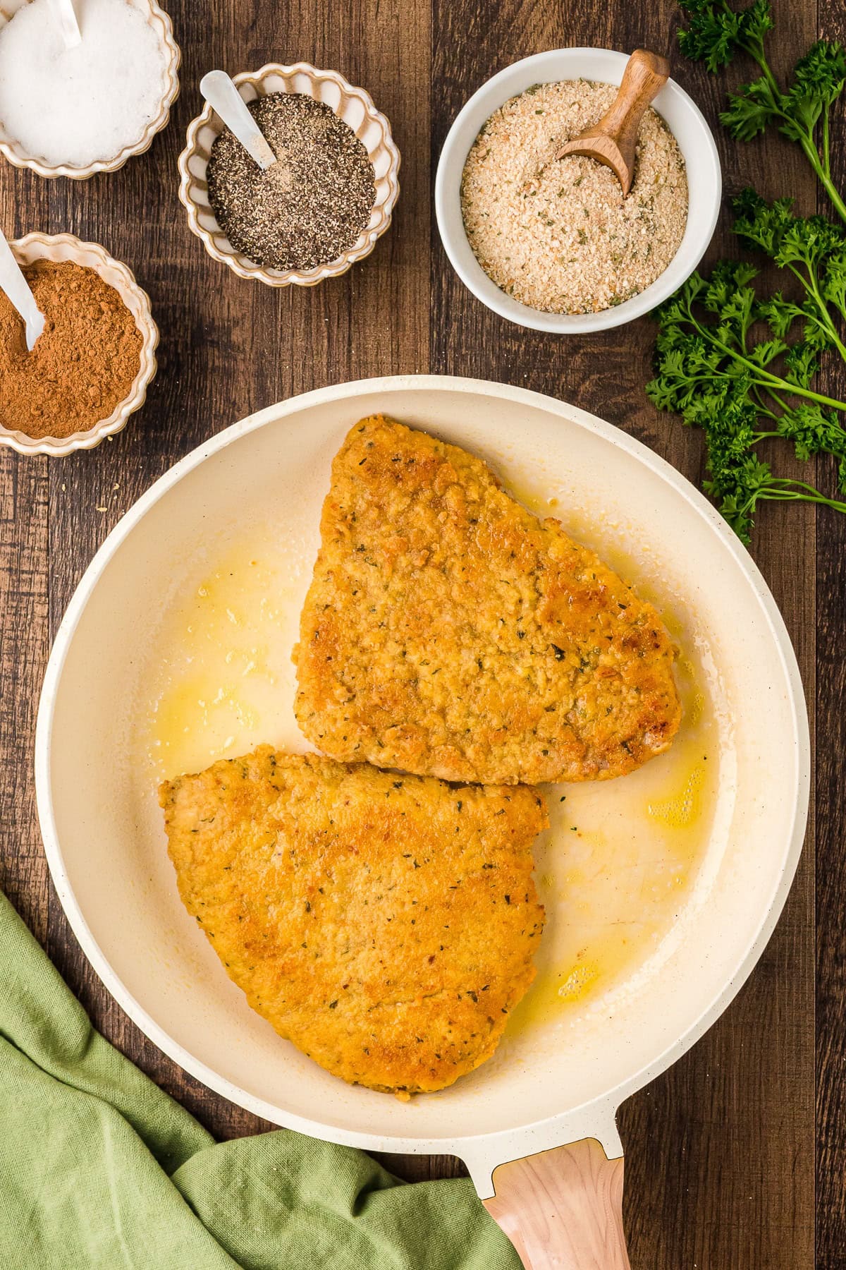 Cooked breaded veal cutlets in a large skillet