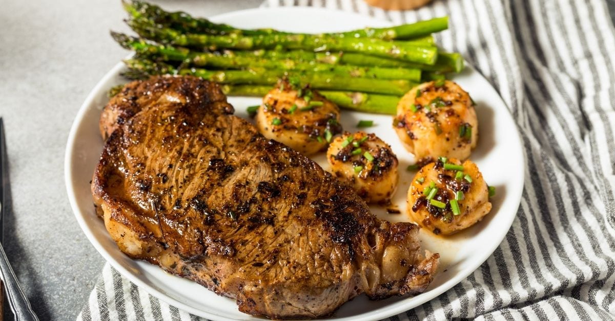 A Plate of Surf and Turf Steak with Scallops and Asparagus
