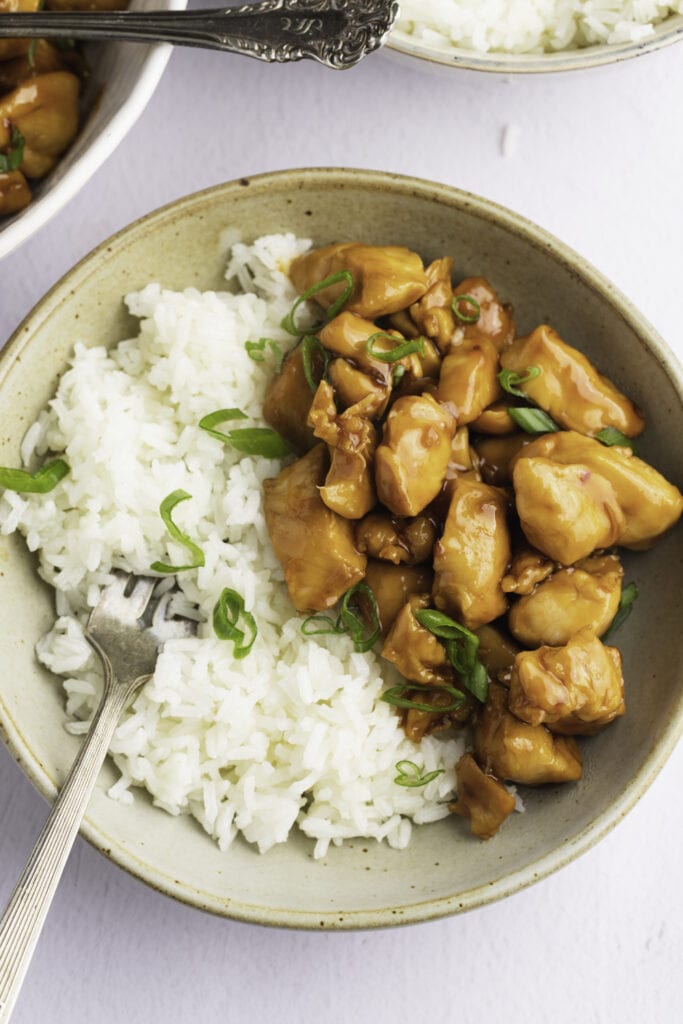 Bourbon Chicken Topped With Scallions Served With Rice