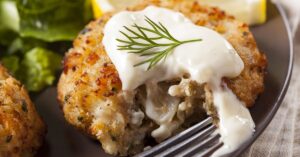 Crab Cakes with Lemon and Tartar Sauce in a Black Plate