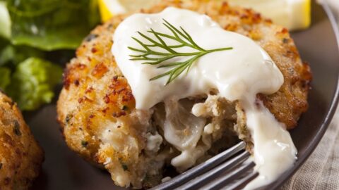Crab Cakes with Lemon and Tartar Sauce in a Black Plate