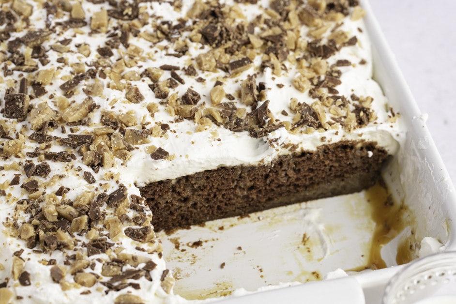 Heath Cake Bar Topped with Chopped Chocolate Caramels in a White Casserole