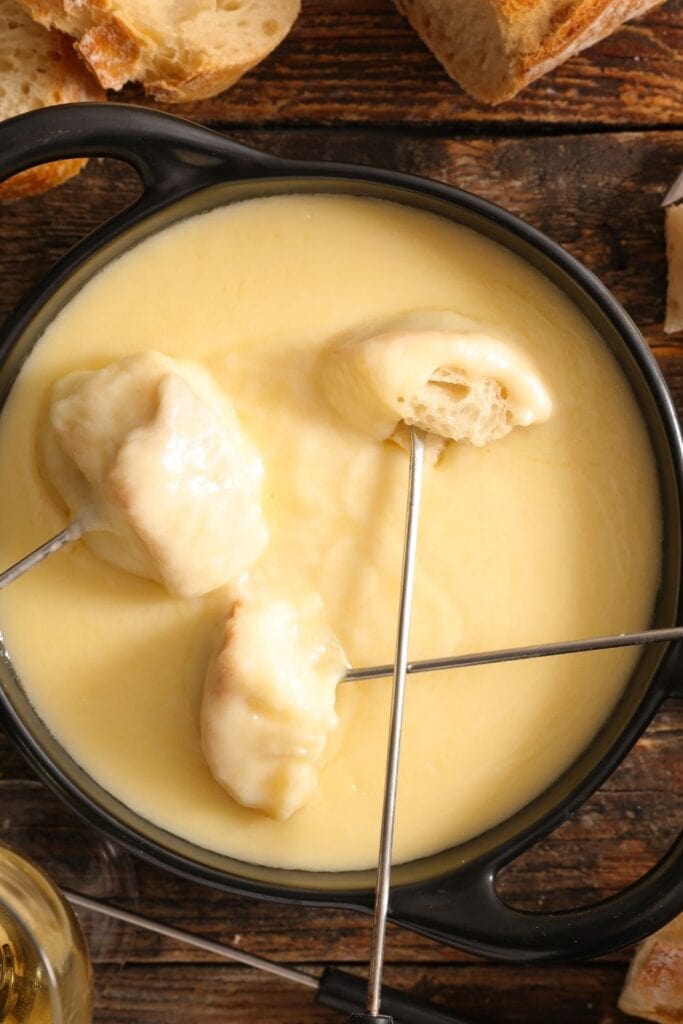 Homemade Cheese Fondue with Skewers and Crusty Bread Pieces