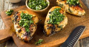 Homemade Grilled Chicken with Pesto in a Wooden Cutting Board
