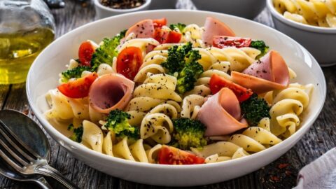 Homemade Ham and Broccoli Pasta with Tomatoes in a White Bowl