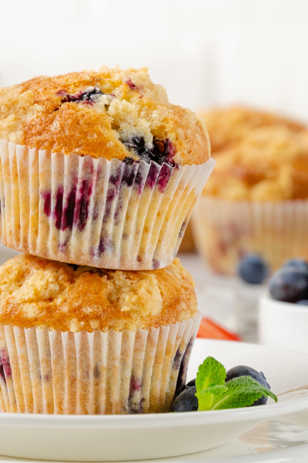 Blueberry muffins stacked on a plate. 